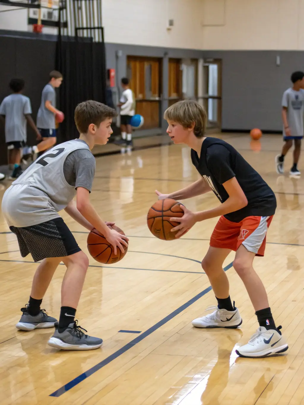 Teenagers practicing basketball drills in the CLUB ATHLETIQUE BALMANAIS gymnasium, with a focus on teamwork and strategy.